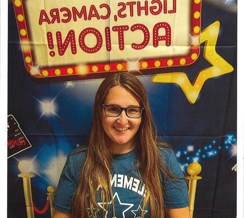 Smiling adult in glasses against a movie-themed backdrop.